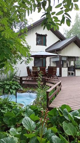 een huis met een terras en een zwembad ervoor bij Talo uima-altaalla in Hämeenlinna