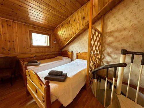 - une chambre avec 2 lits dans une cabane en bois dans l'établissement Home in Bormio, à Bormio