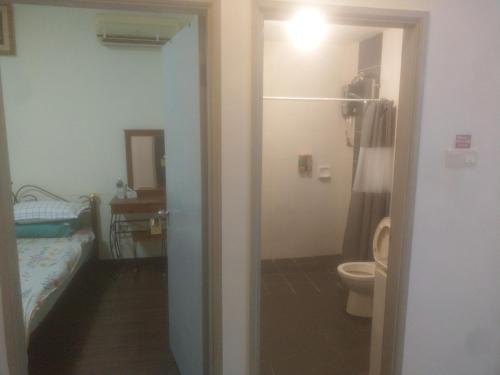 1 dormitorio con 1 cama y baño con aseo. en Sandakan Game Room-Only, en Sandakan