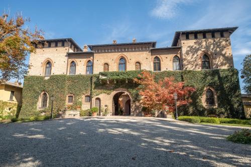 Un grand bâtiment en briques recouvert de lierre dans l'établissement Il Castello Di San Gaudenzio, à Cervesina