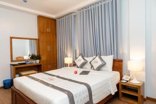 a bedroom with a large white bed with two pillows at Yen Nam Hotel Hoang Van Thu in Ho Chi Minh City
