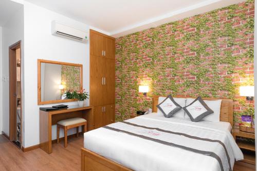 a bedroom with a bed and a brick wall at Yen Nam Hotel Hoang Van Thu in Ho Chi Minh City