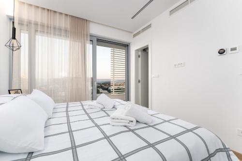 a white bedroom with a large bed with white pillows at Luxury semi detached villa Smokva 2 - near center and sea - by TRAVELER tourist agency Krk in Krk