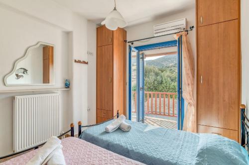 a bedroom with a bed and a door to a balcony at Lovely Apartment With Shared Pool in Aspro Chorio Paros