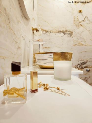 Un baño con artículos dorados y blancos sobre un mostrador. en Apartments Sinković, en Dubrovnik