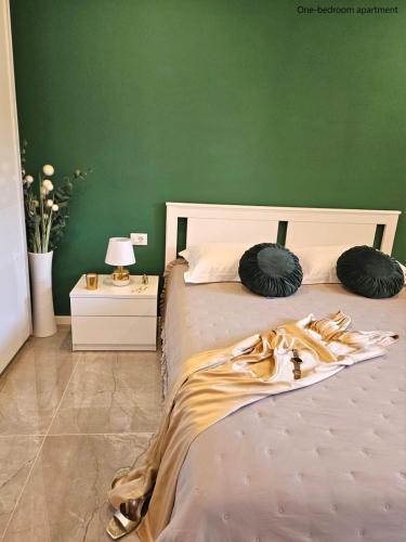 Un dormitorio con una cama con una pared verde. en Apartments Sinković, en Dubrovnik