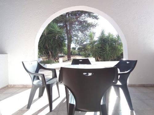 una mesa y sillas en una habitación con un arco en Flower Apartments, en Gouves