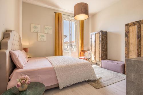 - une chambre avec un lit rose et une grande fenêtre dans l'établissement La Casa di Ely, à Lido di Camaiore