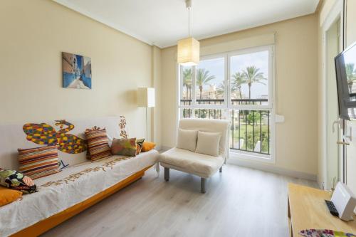 a living room with a couch and a chair and a window at Aquamarinas in Denia