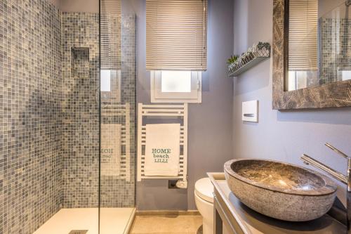 La salle de bains est pourvue d'un lavabo et d'une douche en verre. dans l'établissement La Casa di Ely, à Lido di Camaiore