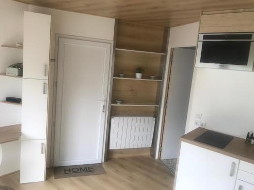 um quarto com uma cozinha com uma porta e prateleiras em Petit studio sur propriété em Orvault
