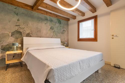 a bedroom with a white bed and a painting on the wall at Ca' Rampani @Venice in Venice