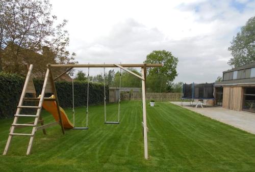 a playground with a swing set in a yard at Hof ter Harte in Ypres