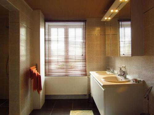 baño con 2 lavabos y espejo grande en Hof ter Harte, en Ypres