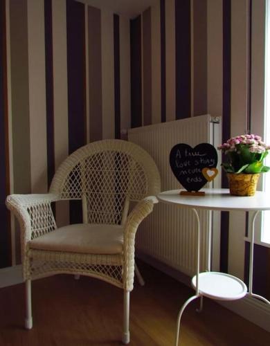 a table with a chair and a table with a bowl of flowers at Hof ter Harte in Ypres