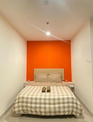 um quarto com uma cama com uma parede laranja em LagoonRoom911 em Pulosirih