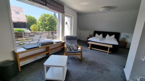 ブラウンラーゲにあるFerienhaus Sauerzapf mit Saunabereich 16 Personenのベッド1台、椅子、窓が備わる客室です。