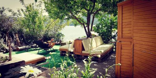 a couch sitting on a patio next to the water at Lakeview Glamping in Staro Myasto