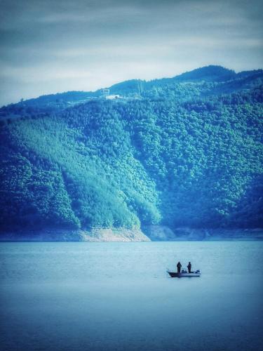 two people are sitting in a boat in the water at Lakeview Glamping in Staro Myasto