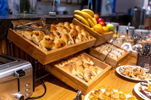 a table with trays of pastries and other food at O2 Hotel Mar del Plata in Mar del Plata