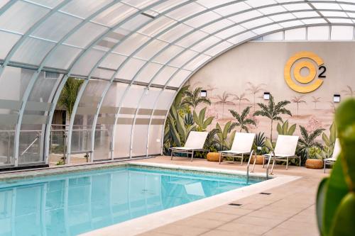 a swimming pool in a building with a glass ceiling at O2 Hotel Mar del Plata in Mar del Plata