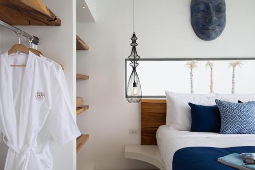a bedroom with a bed with blue and white pillows at Zog Villas in Koh Samui 