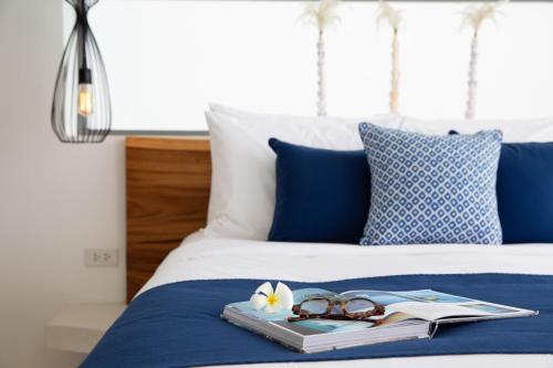 a tray with glasses and a book on a bed at Zog Villas in Koh Samui 