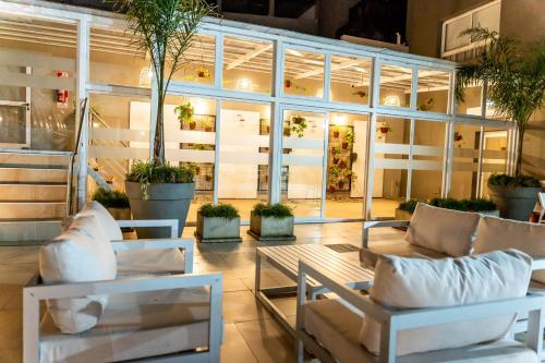 a lobby with white furniture and potted plants at O2 Hotel Mar del Plata in Mar del Plata