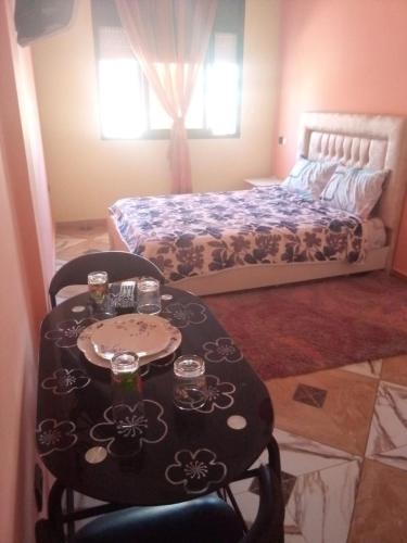 um quarto com uma mesa e uma cama e uma mesa e cadeiras em Blue Meadow em Moulay Bousselham