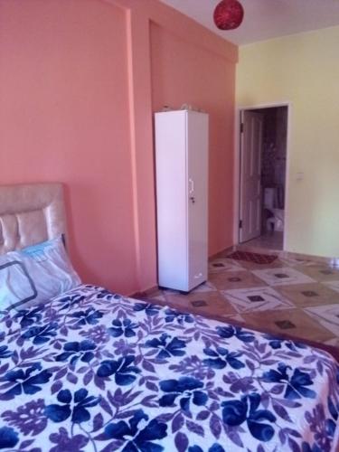 1 dormitorio con 1 cama con colcha de flores azul en Blue Meadow, en Moulay Bousselham