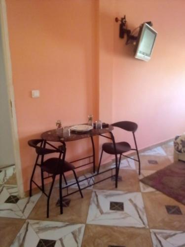 a table and chairs in a room with a tv at Blue Meadow in Moulay Bousselham