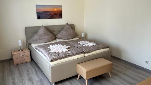 ein Schlafzimmer mit einem Bett mit einem Stuhl und einem Bild in der Unterkunft Ferienhaus Elke in Zinnowitz