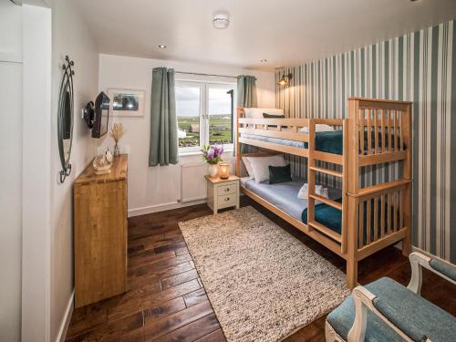 a bedroom with two bunk beds and a window at Two Seas Hebrides in Eoropie