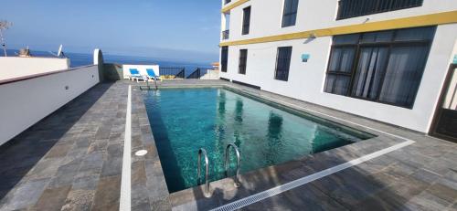 ein Swimmingpool mitten in einem Haus in der Unterkunft Vivienda Vacacional Playa La Arena in Puerto de Santiago