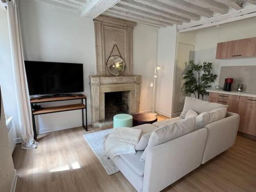un salon avec un canapé blanc et une cheminée dans l'établissement Duplex rénové au Calme et Central, à Caen