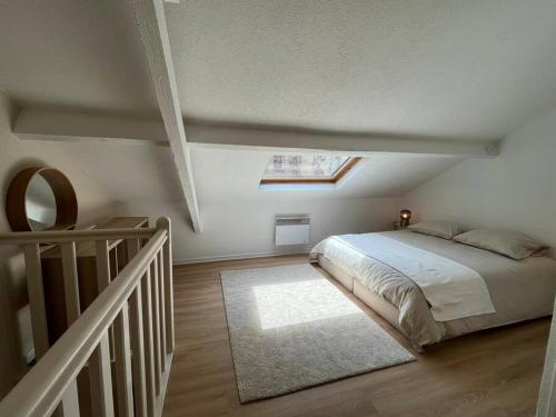 une chambre avec un lit et une lucarne dans l'établissement Duplex rénové au Calme et Central, à Caen