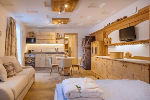 ein großes Wohnzimmer mit einem Sofa und einer Küche in der Unterkunft Cesa dele Angele in Colle Santa Lucia