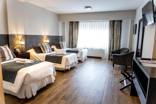 a hotel room with two beds and a couch at O2 Hotel Mar del Plata in Mar del Plata