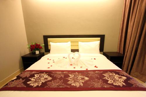 a bed with a white bow on top of it at Paradise Spa Hotel in Port Dickson