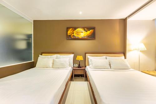 duas camas num quarto de hotel com lençóis brancos em The Noble Swan Central Dong Du Hotel em Ho Chi Minh