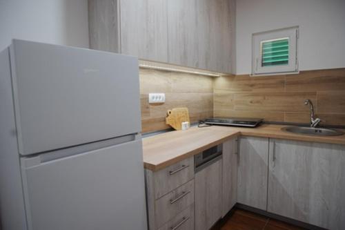 a kitchen with a white refrigerator and a sink at House for rest in Mostar