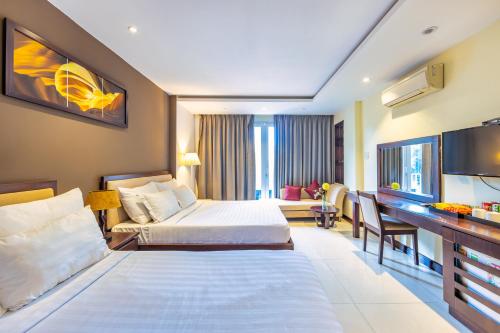 um quarto de hotel com duas camas e uma televisão em The Noble Swan Central Dong Du Hotel em Ho Chi Minh