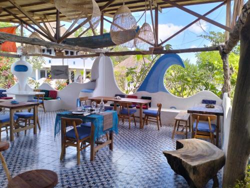 - un restaurant avec des tables et des chaises dans une salle dans l'établissement SHAYA cottage, à Sekotong