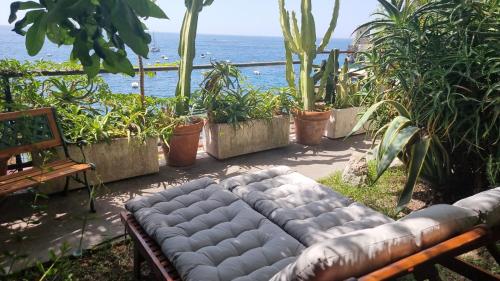 a couch sitting on a patio near the ocean at La Dolce Vita a Positano boutique hotel in Positano