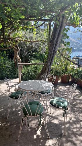 a table and chairs sitting next to a tree at La Dolce Vita a Positano boutique hotel in Positano