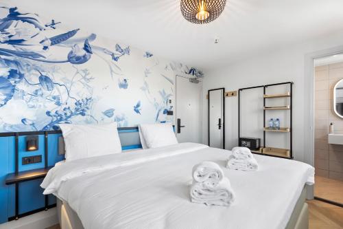 1 dormitorio con 1 cama con toallas en Dutch Design Hotel Vondelpark, en Ámsterdam