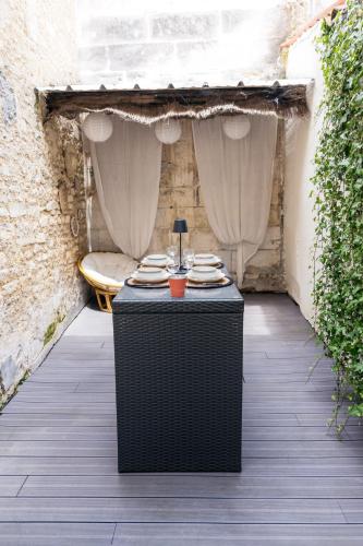 - une table avec des plaques sur la terrasse dans l'établissement Coquette maison & extérieur, à Cognac