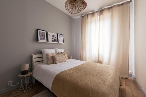 Un dormitorio con una cama grande y una ventana en Coquette maison & extérieur en Cognac