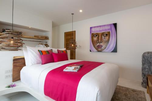 a bedroom with a large bed with a painting on the wall at Zog Villas in Koh Samui 