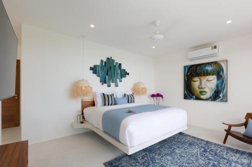 a bedroom with a bed with a painting on the wall at Zog Villas in Koh Samui 